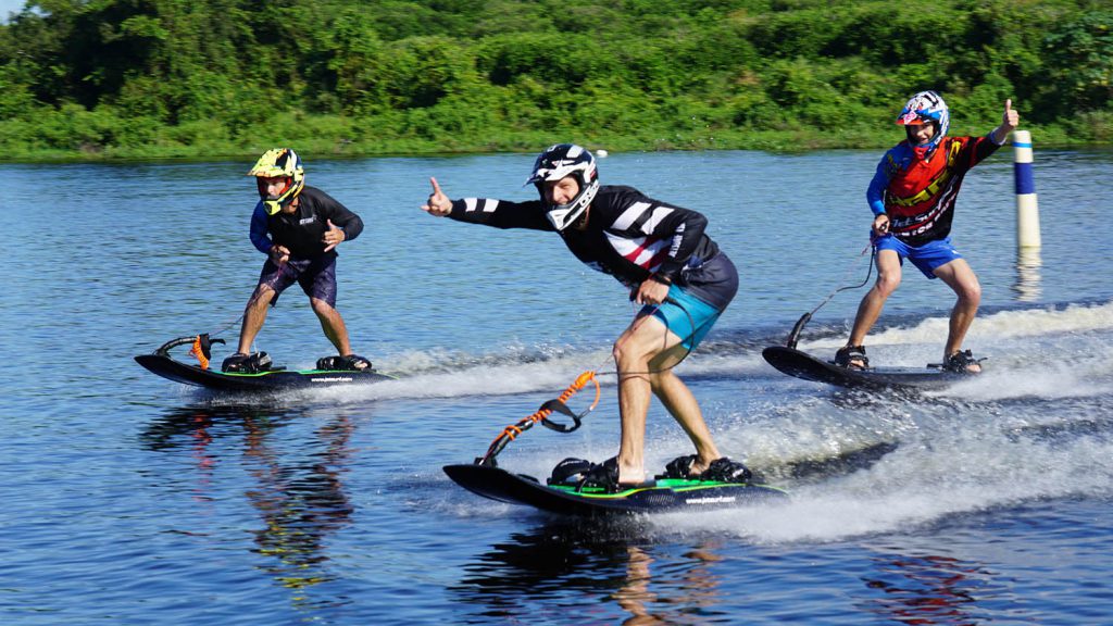 Three people riding the waves in the lake using Jet Surf.