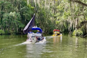 Two cat boats float into the Dora Canal.