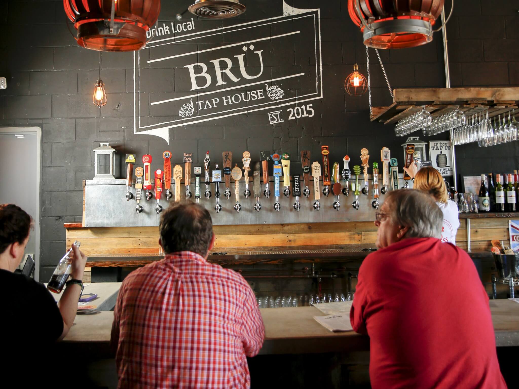 Interior, Bru Tap House, Tavares. Three people are sitting at the bar.